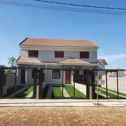 Fachada de uma casa residencial em Lajeado, Brasil, com cerca e paisagismo frontal.