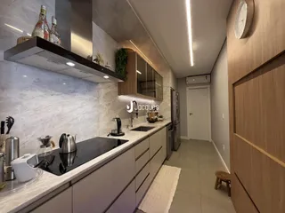 Cozinha moderna com armários brancos e bancadas claras.