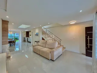 Sala de estar com piso de cerâmica e sofá claro em um imóvel em Lajeado.