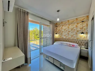 Quarto com cama e porta de vidro dando para o exterior.