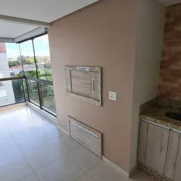 Sala de estar com piso de cerâmica e portas de vidro que dão acesso ao exterior.
