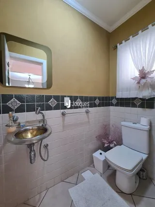 Foto de um banheiro com azulejos brancos e louças sanitárias.