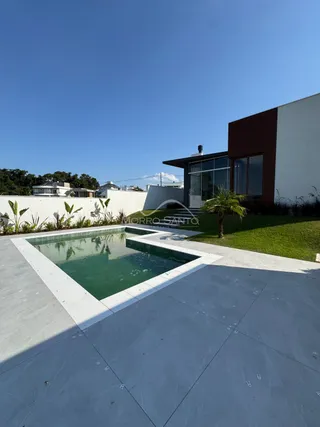 Foto de uma piscina externa com deck em uma residência.