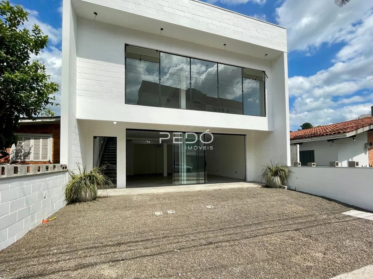 Fachada moderna de uma residência em Lajeado, Brasil com grandes janelas de vidro.