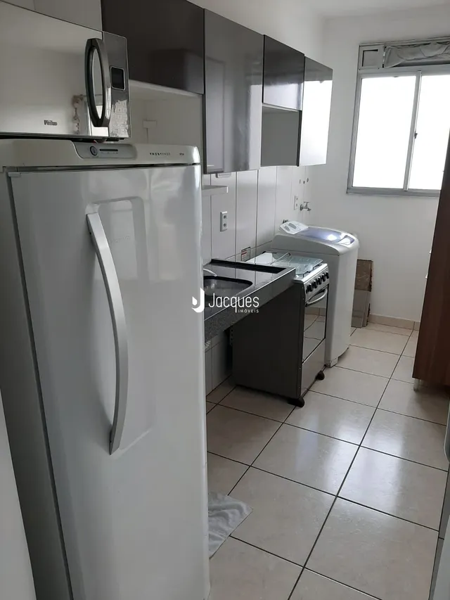 Foto de uma cozinha moderna com armários brancos e piso cerâmico.