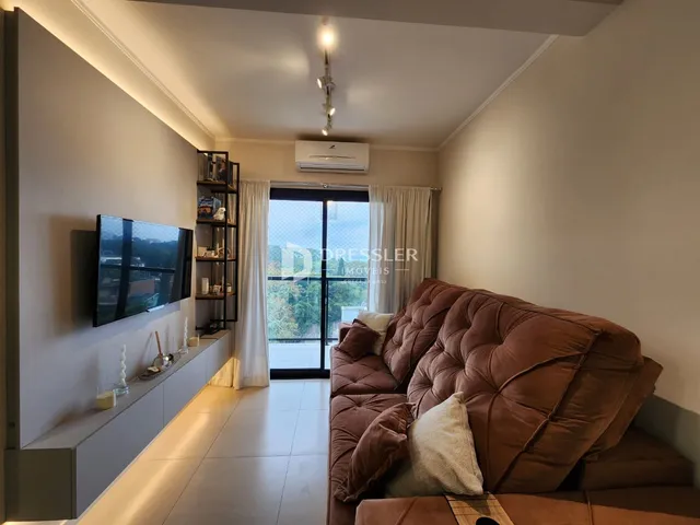 Sala de estar com sofá e televisão em um apartamento.
