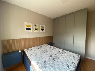 Quarto com cama grande e armário em um ambiente claro.