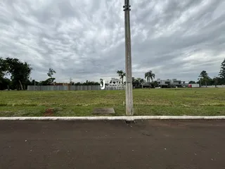 Vista externa de uma propriedade com gramado e poste no meio.
