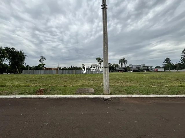 Vista externa de uma propriedade com gramado e poste no meio.