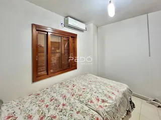 Quarto com cama e armário de madeira na parede.
