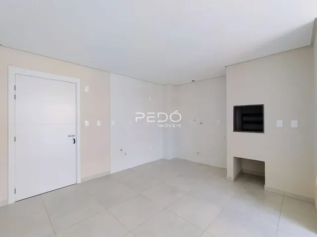 Ambiente interno de uma sala com piso claro e paredes brancas.