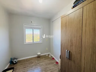 Quarto interno com piso de madeira e armário grande.