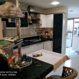 Foto interna de uma cozinha com armários e bancadas.