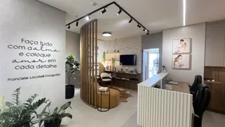 Sala de estar com decoração moderna e parede com frase decorativa.