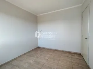 Parede branca e piso de cerâmica em um ambiente interno.