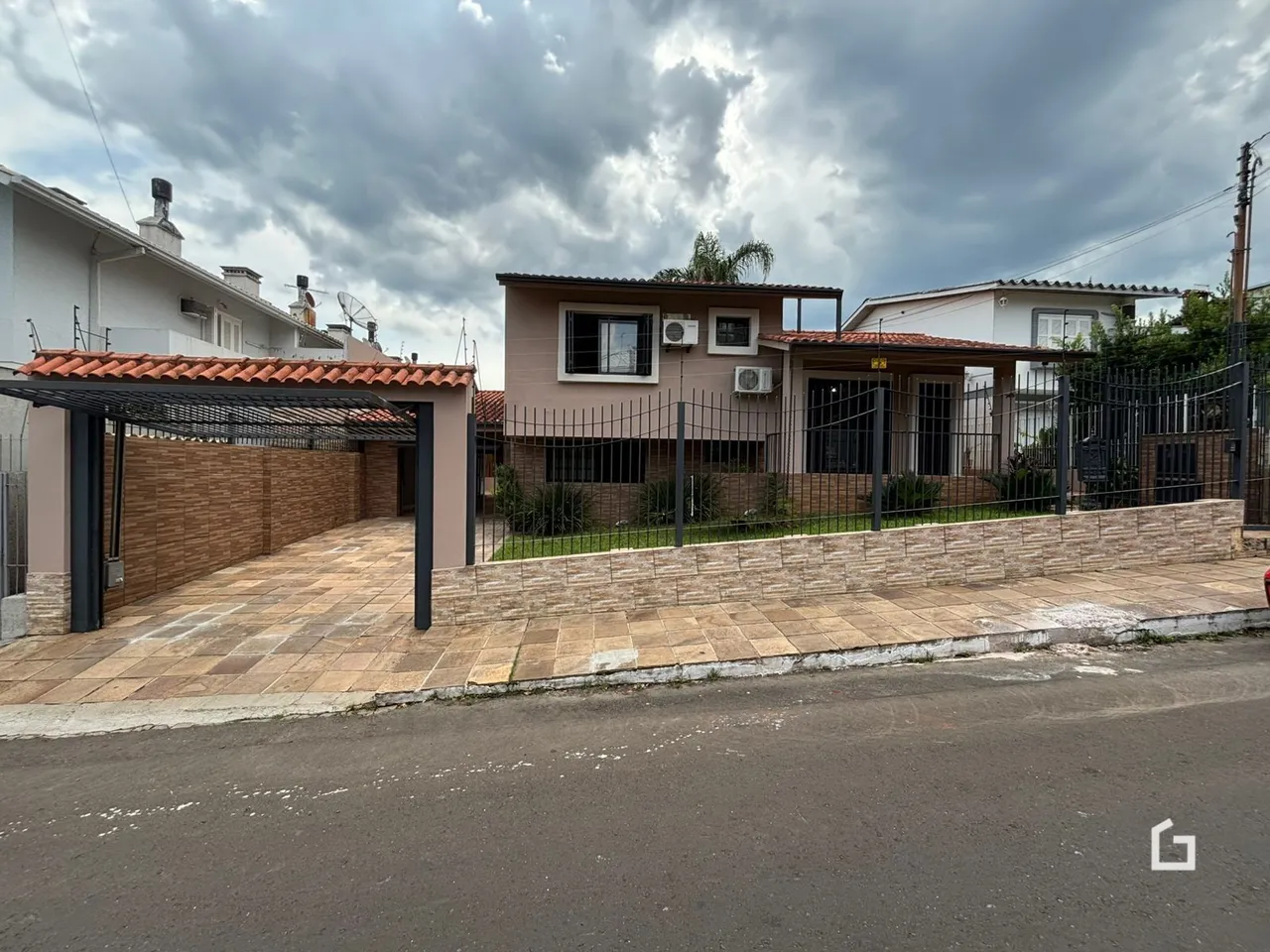 Fachada de uma casa em Lajeado, Brasil com muro e área pavimentada.