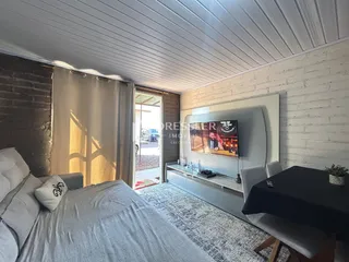 Quarto com cama e janela em ambiente interno.