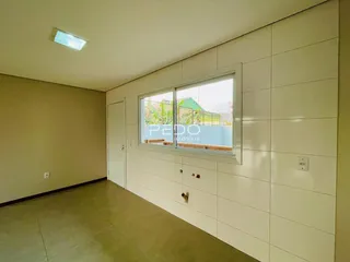 Vista interna de um ambiente com paredes claras e piso de cerâmica.