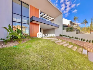 Fachada moderna de uma residência em Lajeado, Brasil, com jardim gramado em primeiro plano.