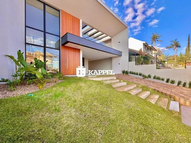 Fachada moderna de uma residência em Lajeado, Brasil, com jardim gramado em primeiro plano.