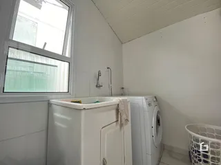 Foto de um banheiro com banheira e máquina de lavar roupa em uma residência.