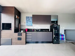 Imagem de uma cozinha moderna com armários escuros e piso claro.
