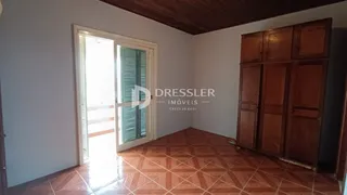 Interior de uma sala com piso de cerâmica e armário de madeira.