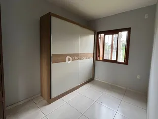 Quarto com armário embutido e janela de madeira em Lajeado.