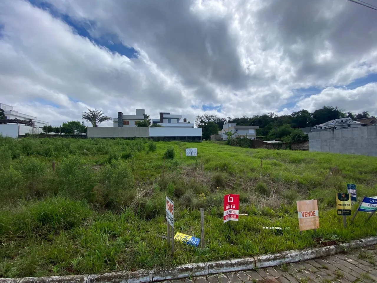 Foto externa mostrando um terreno com vegetação alta em frente a uma residência em Lajeado.