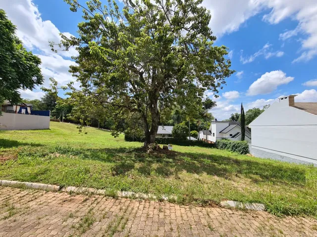 Vista externa da propriedade mostrando um gramado e uma árvore na frente.