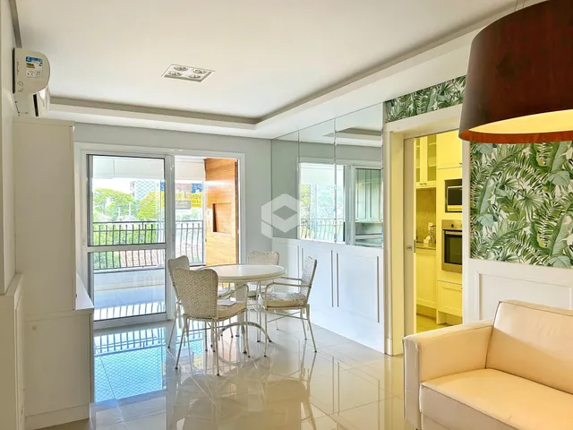 Sala de estar com vista para o exterior e área de jantar em um imóvel no Brasil.