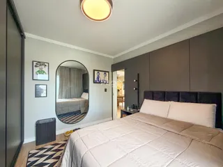 Quarto com cama grande e decoração moderna em um imóvel no Brasil.