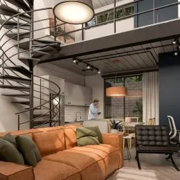 Foto de uma sala de estar com sofá e escadaria metálica.