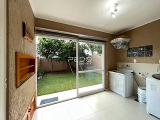 Sala de estar com porta de vidro que dá acesso a um quintal gramado.