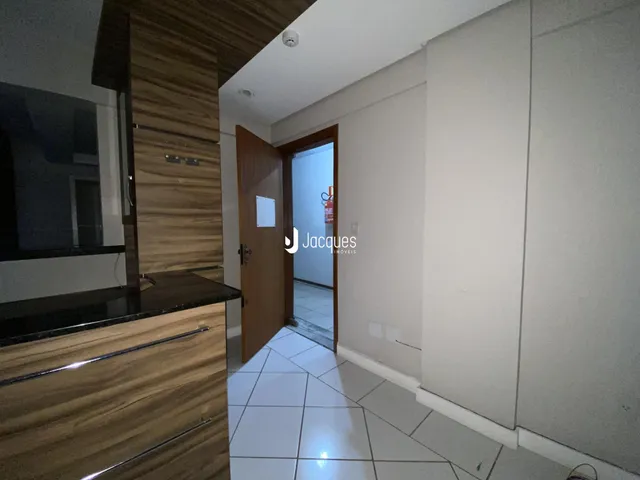 Interior de uma sala com piso de cerâmica e armários de madeira.
