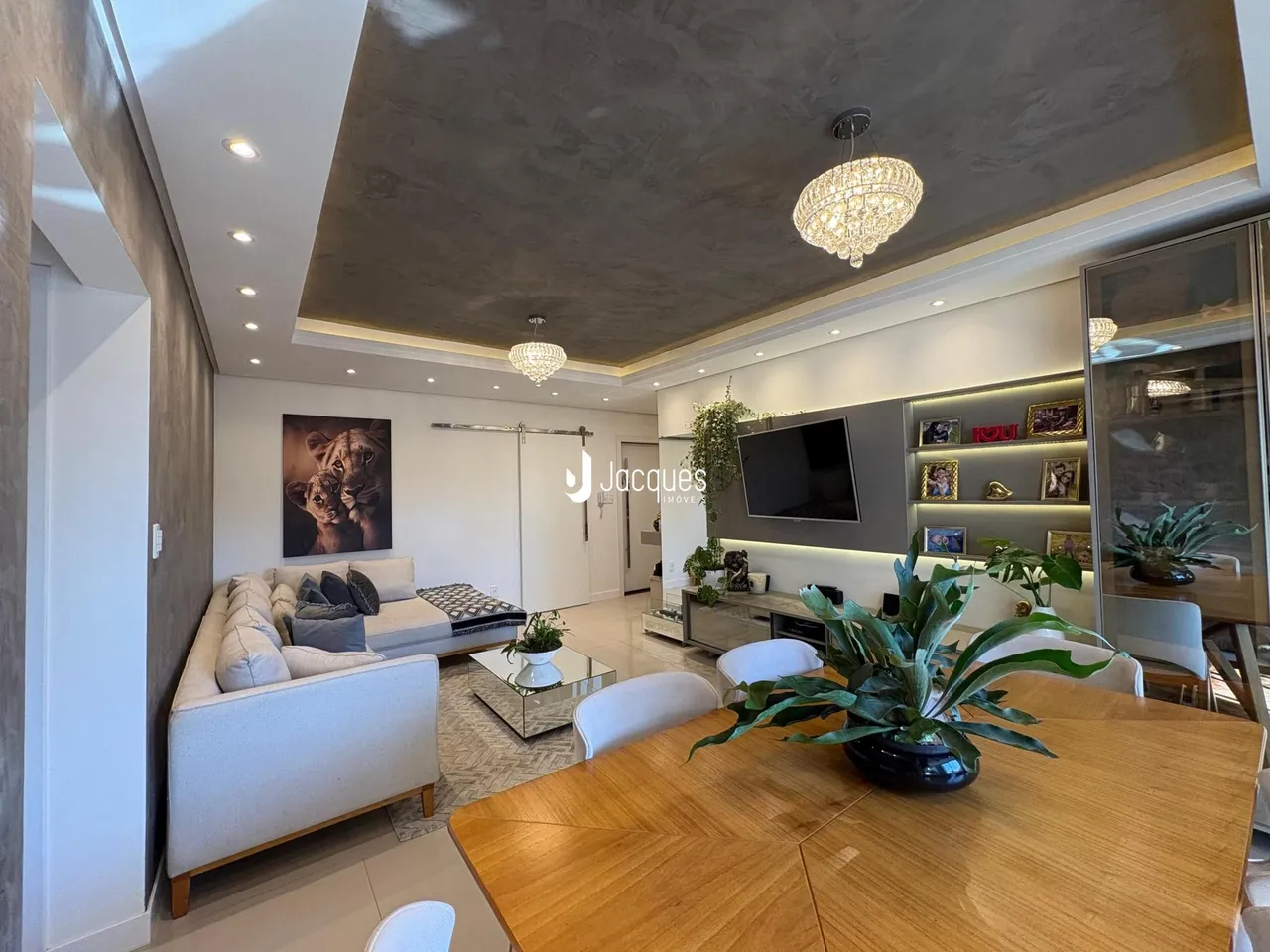 Sala de estar e jantar moderna com piso de madeira e teto alto.