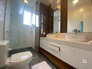 Foto de um banheiro com revestimento cerâmico e louças sanitárias modernas.