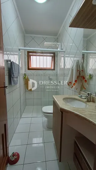 Interior de um banheiro com piso de cerâmica e paredes brancas.