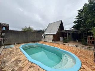 Foto da área externa com uma piscina e uma estrutura de madeira.