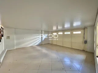 Interior de uma sala com piso de cerâmica clara e teto branco.
