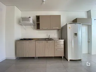 Foto de uma cozinha com armários e eletrodomésticos brancos.