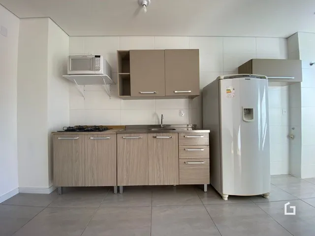 Foto de uma cozinha com armários e eletrodomésticos brancos.