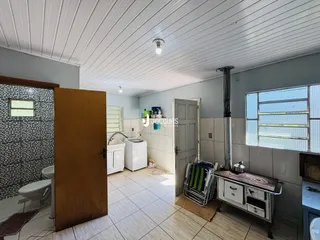 Foto interna de um banheiro com piso de cerâmica e porta de madeira.