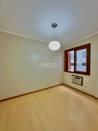 Foto de uma sala com piso de madeira clara e janela de madeira.