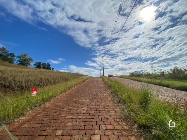 Um caminho de tijolos vermelhos se estende por uma área de campo gramado.