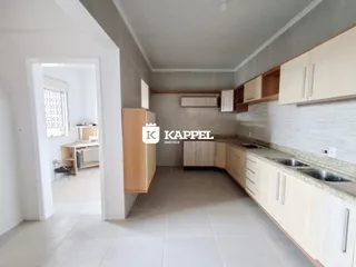 Foto da cozinha com armários claros e piso de cerâmica.