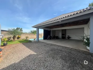 Vista da fachada de uma residência com garagem coberta e jardim em Lajeado.