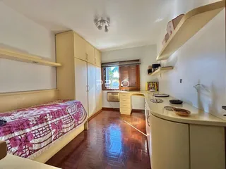 Quarto com armários embutidos e piso de madeira no imóvel.