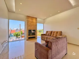 Sala de estar moderna com grandes janelas e lareira em Lajeado.