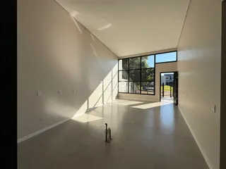 Espaço interno amplo com paredes brancas e piso claro.